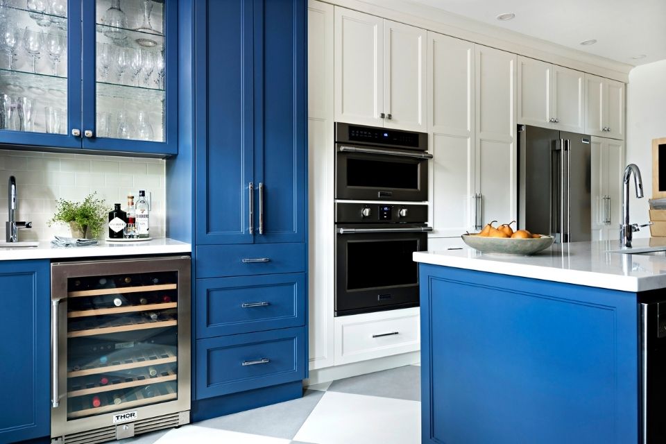 Bright blue accent cabinets on wet bar in white kitchen